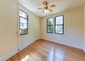 Thumbnail 17 of 28 - vacant bedroom with hardwood floorings, large windows and ceiling fan at the klingle apartments in washignton dc