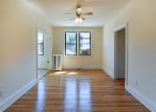 Thumbnail 18 of 28 - vacant living area with hardwood flooring, large windows and ceiling fan at the klingle apartments in washignton dc