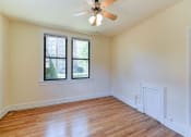 Thumbnail 21 of 28 - vacant bedroom with hardwood floorings, large windows and ceiling fan at the klingle apartments in washignton dc