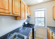 Thumbnail 2 of 33 - kitchen with gas range, oak cabinetry and window at the meridian park apartments in columbia heights washington dc