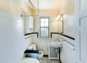 Thumbnail 19 of 33 - bathroom with tub, toilet, sink, medicine cabinet, mirror and window at the meridian park apartments in columbia heights washington dc