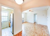 Thumbnail 12 of 33 - vacant living area with hardwood floors, ceiling fan and view of kitchen at the meridian park apartments in columbia heights washington dc