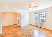 Thumbnail 11 of 33 - vacant living area with hardwood floors, ceiling fan, window and view of dining area at the meridian park apartments in columbia heights washington dc