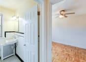 Thumbnail 18 of 33 - hallway view of bedroom with hardwood floors, ceiling fan and bathroom at the meridian park apartments in columbia heights washington dc