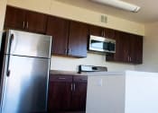 Thumbnail 3 of 6 - kitchen with espresso cabinetry, stainless steel appliances, and breakfast bar at sheridan station apartments in washington dc