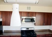 Thumbnail 4 of 6 - kitchen with espresso cabinetry, stainless steel appliances, and breakfast bar at sheridan station apartments in washington dc