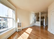 Thumbnail 16 of 35 - vacant living area with hardwood flooring, large windows and view of kitchen at dupont apartments in washington dc