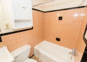 Thumbnail 10 of 35 - bathroom with tub, toilet, medicine cabinet and tile details at dupont apartments in washington dc