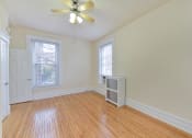 Thumbnail 24 of 35 - vacant bedroom with hardwood floors, large windows and ceiling fan at dupont apartments in washington dc