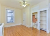 Thumbnail 23 of 35 - vacant bedroom with hardwood floors, ceiling fan, large closet and view of bathroom at dupont apartments in washington dc