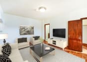Thumbnail 6 of 20 - living area with sofa, coffee table, hardwood floors and view of bedroom at eddystone apartments in washington dc