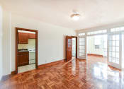 Thumbnail 7 of 20 - vacant living area with large windows, hard wood flooring and  view of kitchen and sunroom at eddystone apartments in washington dc