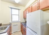 Thumbnail 3 of 20 - kitchen with wood cabinetry, electric range, refrigerator, and window at eddystone apartments in washington dc