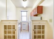Thumbnail 16 of 20 - kitchen with wood cabinetry, electric range, refrigerator, and window at eddystone apartments in washington dc