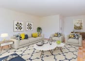 Thumbnail 9 of 19 - living area with coffee table, social seating, tv, credenza and hardwood flooring at fort totten apartments in washington dc