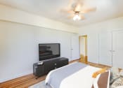Thumbnail 10 of 29 - bedroom with bed, dresser, tv, hardwood flooring,, ceiling fan and large closet at the frontenac apartments in washington dc