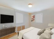 Thumbnail 6 of 15 - bedroom with bed, nightstands, and tv at garden village tax credit apartments in congress heights washington dc