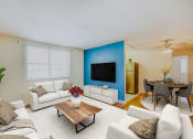 Thumbnail 3 of 15 - a living room with a blue accent wall and a white couch at garden village tax credit apartments in washington dc