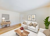 Thumbnail 4 of 15 - a living room with a white couch and a wooden coffee table at garden village tax credit apartments in congress heights washington dc