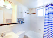 Thumbnail 7 of 15 - bathroom with tub, toilet, mirror, vanity and small windows at garden village tax credit apartments in congress heights washington dc