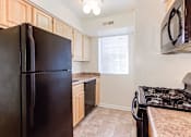 Thumbnail 2 of 16 - kitchen with refrigerator, gas range and window at grandview village apartments in shipley terrace washington dc