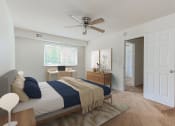 Thumbnail 9 of 13 - a bedroom with a bed and a ceiling fan and a door to a bathroom at halley house apartments in washington dc