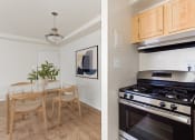 Thumbnail 7 of 13 - a kitchen and a dining room with a stove and a table at halley house apartments in washington dc