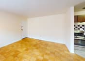 Thumbnail 10 of 13 - a living room with a wood floor and a kitchen