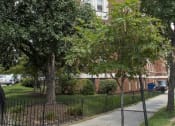 Thumbnail 21 of 25 - a tall brick building with trees in front of it