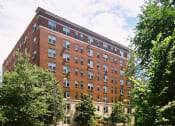 Thumbnail 20 of 25 - a tall brick building with trees in front of it