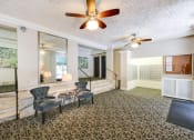 Thumbnail 18 of 25 - a living room with two chairs and a ceiling fan