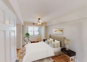Thumbnail 5 of 19 - bedroom with bed, night stands, ceiling fan and large windows  at hilltop house apartments in columbia heights washington dc