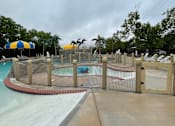 Thumbnail 18 of 21 - A pool area with a fence and a water slide.