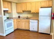 Thumbnail 7 of 18 - kitchen with gas range, oak cabinetry, and view of hallway at 3101 pennsylvania apartments in washington dc