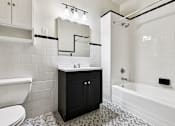 Thumbnail 26 of 32 - A white bathroom with black and white tiles.