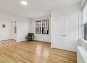 Thumbnail 36 of 64 - A room with wooden floors and white walls.
