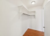 Thumbnail 6 of 21 - A white room with a wooden floor and a door.