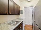 Thumbnail 5 of 21 - A kitchen with a sink and a refrigerator.