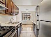 Thumbnail 16 of 36 - A kitchen with a black stove top oven and a black refrigerator.