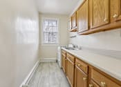 Thumbnail 14 of 20 - A kitchen with wooden cabinets and a window.