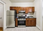 Thumbnail 2 of 32 - A kitchen with a refrigerator, oven, and cabinets.