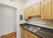 Thumbnail 8 of 21 - A kitchen with wooden cabinets and a granite countertop.