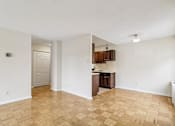 Thumbnail 17 of 36 - A kitchen area with wooden flooring and white walls.