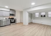 Thumbnail 37 of 64 - A kitchen with wooden floors and a white wall.