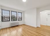 Thumbnail 44 of 64 - A room with wooden floors and white walls, with a window and a door.
