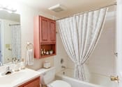 Thumbnail 6 of 18 - A white bathroom with a white tub and a white shower curtain.