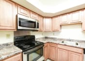 Thumbnail 3 of 14 - kitchen with stainless steel appliances and wood cabinetry at jasper place apartments in congress heights washington dc