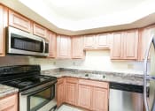 Thumbnail 1 of 14 - kitchen with stainless steel appliances and wood cabinetry at jasper place apartments in congress heights washington dc