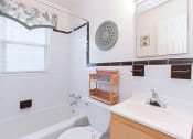 Thumbnail 11 of 16 - bathroom with toilet, tub, vanity and mirror at jetu apartments in washington dc