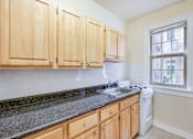 Thumbnail 2 of 21 - kitchen with tile floorings, wood cabinetry, refrigerator and gas range at 3151 mount pleasant apartments in washington dc